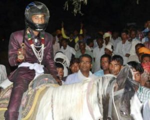 The bridegroom in a helmet on a horse