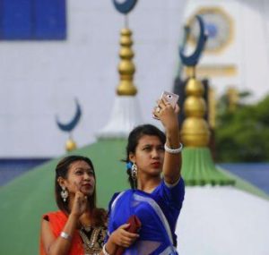 Nepali Muslim girls take a selfie outside the Kashmiri Mosque in Kathmandu