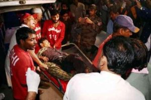 Injured boy being carried out of the shrine. EPA photo.