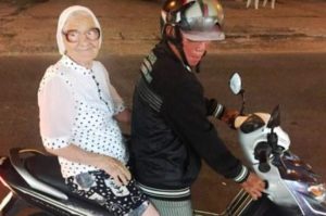 Granny Lena charms a local gentleman who fives her a scooter ride